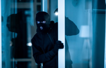 watchful thief lurking into residential building through open front door